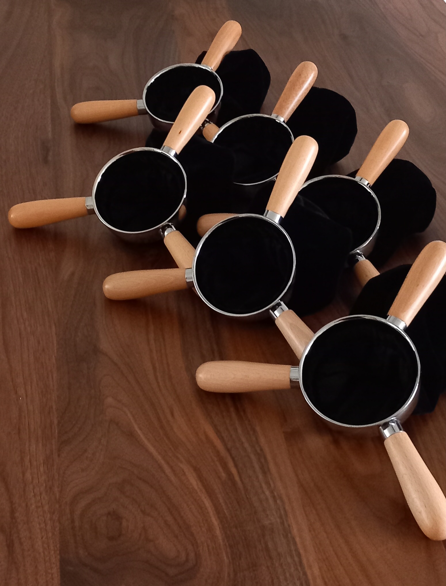 Zwarte collectezakken met drie beuken houten handgrepen.